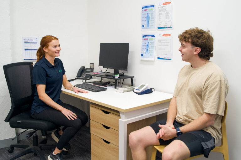 Man and P4 Movement Physiotherapist discussing whether posture is causing him pain at P4 Movement in Wollongong